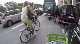 (GoPro dashcam) Cyclist stuck between a bus and a van knocks hard to alert about the danger. Paris, rue de Rivoli