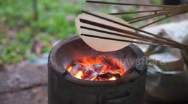 Traditional hand made rice crackers being made by hand using a charcoal stove.