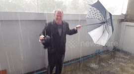 Crazy funny fat man dancing and takes off his shirt in the rain.