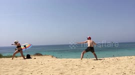 Couple pull funny 'Mortal Kombat' poses while playing with ball on beach