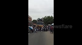 Terrifying moment celebrating students fall from top of moving bus in southern India