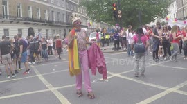 Man on skates in pride gear almost trips over can but acts as if nothing happened