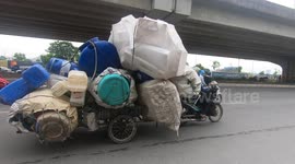 Ridiculously overloaded tricycles carrying many plastic containers and foam boxes