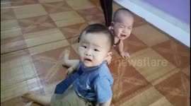 Hilarious video of a baby terrified of a younger than him baby