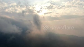 Through clouds and mountains at sunset.