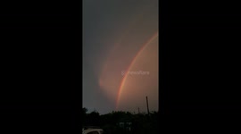 Vibrant double rainbow with lightning storm in Florida