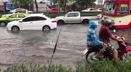 Motorists drive through flood waters during morning rush hour in Bangkok