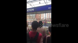 Commuters wait outside evacuated Victoria station after fire alert