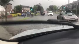 Scottish man appears unphased sitting on top of his car in the middle of a flood