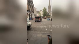 Bartenders chase after furniture being swept away by flooding in Scotland