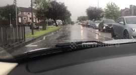 Man sits on roof of stranded car in flooded road in Edinburgh