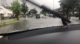 Man sits on roof of stranded car in flooded road in Edinburgh