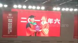 Nervous graduate forgets to take diploma after having picture with university president in China
