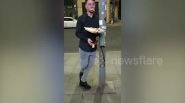 Hilarious moment drunk man eating kebab drops to the floor after leaning on lamppost