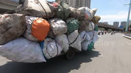 Overloaded motorbike carrying 21 giant sacks moved very fast on the road