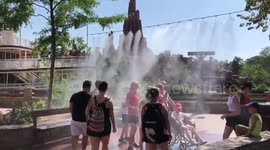 Families visiting Disneyland Paris cool down under water mist during European heatwave