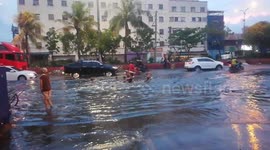 Children go 'bodyboarding' on flooded road in the Philippines following heavy downpours