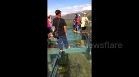 Nervous tourists tread carefully over glass bridge in Indonesia