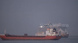 The large cruise ship MSC Seaview arriving into Barcelona port at sunrise with cargo ship in the foreground