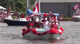 Canada day holiday celebrations in Port Dover with boats covered in Canadian flags and people enjoying the nice summer weather