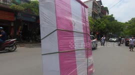 Flying wardrobe? Motorcyclist drives with huge cabinet on busy road in Vietnam