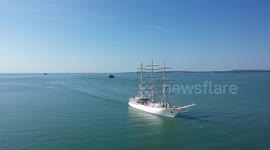 Sailors stand on the yardarms of the Algerian Naval Tall Ship ‘El Mellah’ as it enters Portsmouth harbour