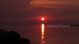 A glowing beam of light from an ocean sunset on the ocean.