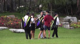Thai graduate students blow bubbles and take photos in a park.