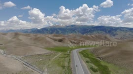 Drone video of Desert Mountain and road in the middle, South of Naryn, Central Asia, Kyrgyzstan…