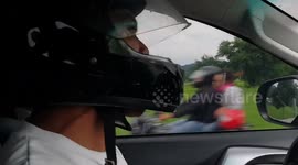Filipino man driving a car wears helmet to make point about road safety