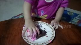 Babies eat cakes, their faces are covered in cream