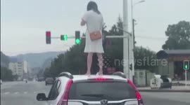 Angry woman climbs onto car roof on Chinese highway after 'arguing with husband'