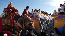 Thai monks ride elephants while receiving donations to mark the start of Buddhist Lent