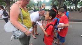 Vietnamese children learn English by communicating with foreign tourists on the street.