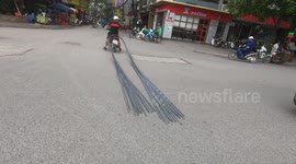 Motorbike stops traffic while dragging 6-metre long bundle of steel through crowded street