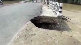 Part of road caves-in following bridge collapse caused by heavy rains in northern India