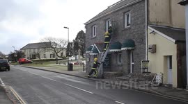 firemen battle strong winds of dartmoor to stop sign falling on public