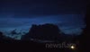 Electric Blue NLCs Over Busy Road At Night