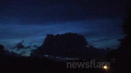 Electric Blue NLCs Over Busy Road At Night