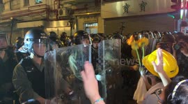 Hong Kong protesters attempt to give flowers to riot police before streets are cleared