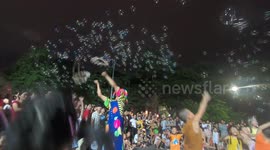 The children are playing with soap bubbles created by circus artist