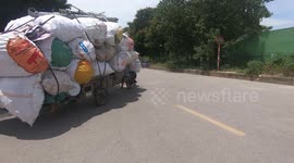Overload tricycles carrying dozens of giant sacks Moves Through Streets Of Ha Noi