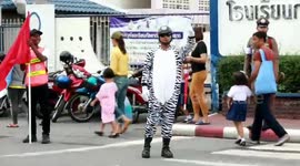 Kind-hearted policeman dresses as zebra to help children cross the road in Thailand