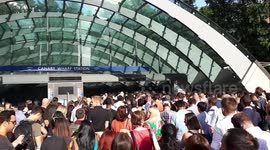 Commuters queue outside Canary Wharf station in 32C heat