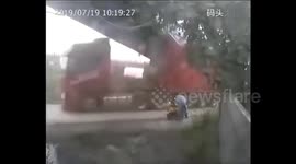Truck trailer narrowly misses man after smashing into bridge in China