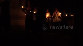 Thai Buddhists walk around a temple three times with lighted candles, on a special Buddhist holy day.