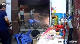 Car crashes into shop in southern China narrowly avoiding two men