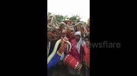 Devotees coil live snakes around the necks during bizarre Hindu festival in Bihar