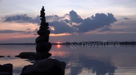 Sunset over a tranquil lake in Thailand.
