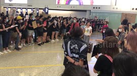Pro-democracy protesters greet arriving passengers at Hong Kong airport